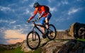 Cyclist Riding Mountain Bike Down Spring Rocky Hill at Beautiful Sunset. Extreme Sports and Adventure Concept. Royalty Free Stock Photo