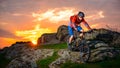 Cyclist Riding Mountain Bike Down Spring Rocky Hill at Beautiful Sunset. Extreme Sports and Adventure Concept. Royalty Free Stock Photo