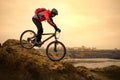 Cyclist Riding the Mountain Bike on the Rocky Trail at Cold Autumn Evening. Extreme Sport and Enduro Cycling Concept. Royalty Free Stock Photo