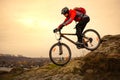 Cyclist Riding the Mountain Bike on the Rocky Trail at Cold Autumn Evening. Extreme Sport and Enduro Cycling Concept. Royalty Free Stock Photo