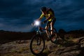 Cyclist Riding the Mountain Bike on Rocky Trail at Night. Extreme Sport and Enduro Biking Concept. Royalty Free Stock Photo