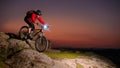 Cyclist Riding the Mountain Bike on Rocky Trail at Night. Extreme Sport and Enduro Biking Concept. Royalty Free Stock Photo