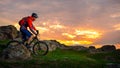 Cyclist Riding Mountain Bike on the Spring Rocky Trail at Beautiful Sunset. Extreme Sports and Adventure Concept. Royalty Free Stock Photo