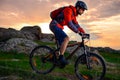 Cyclist Riding Mountain Bike on the Spring Rocky Trail at Beautiful Sunset. Extreme Sports and Adventure Concept. Royalty Free Stock Photo