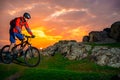 Cyclist Riding Mountain Bike on the Spring Rocky Trail at Beautiful Sunset. Extreme Sports and Adventure Concept. Royalty Free Stock Photo