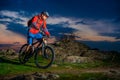 Cyclist Riding Mountain Bike on Spring Rocky Trail at Beautiful Sunset. Extreme Sports and Adventure Concept. Royalty Free Stock Photo