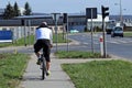 The cyclist is riding by the sidewalk near the road on which the cars are going. Transport city system. Ecological type of transpo