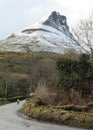 Cyclist on road at foot of snow-covered Benwiskin mountain Royalty Free Stock Photo