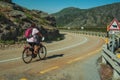 Cyclist on road passing a rocky landscape