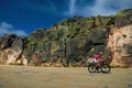 Cyclist on roadway passing through rocky landscape