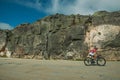 Cyclist on roadway passing through rocky landscape