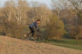 Cyclist in shorts and jersey on a modern carbon hardtail bike with an air suspension fork standing on a cliff against the backgrou