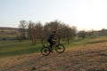 Cyclist in shorts and jersey on a modern carbon hardtail bike with an air suspension fork standing on a cliff against the backgrou