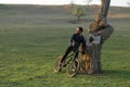 Cyclist in shorts and jersey on a modern carbon hardtail bike with an air suspension fork standing on a cliff against the backgrou