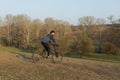 Cyclist in shorts and jersey on a modern carbon hardtail bike with an air suspension fork standing on a cliff against the backgrou