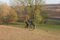 Cyclist in shorts and jersey on a modern carbon hardtail bike with an air suspension fork standing on a cliff against the backgrou