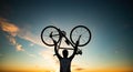 cyclist silhoutte with bicycle raised to sky race and victory concept