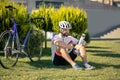 Cyclist sitting on the grass near the bike