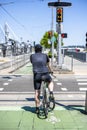 Cyclist in sportswear stands at a crossroads waiting for a green traffic light for bicycles in an urban city Royalty Free Stock Photo