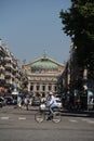 a cyclist through the streets of Paris with a view of the Opera Garnier in the background France