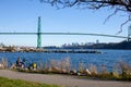 A cyclist takes a break in Ambleside Park with a view of Lionsgate bridge Royalty Free Stock Photo