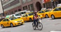 Cyclist in traffic between the yellow cabs in Manhattan, NYC. Royalty Free Stock Photo