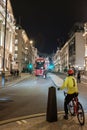 A cyclist waiting patiently to cross the street central London at night