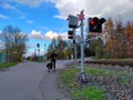 A cyclist is waiting at railway crossing with stoplights being turned on Royalty Free Stock Photo