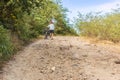 Cyclist walking with bicycle on a steep dirt road v 280 near Rio