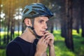 Cyclist is wearing a sports helmet on his head in the background of green nature. Protection during mountain Biking