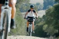 Real cyclist woman pedaling hard on an uphill mountain climb