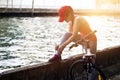 Cyclist woman tying shoeslace along the canal in sunset Royalty Free Stock Photo