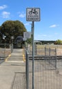 Cyclists dismount sign at a railway crossing with a blue sky