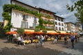 Cyclists driving next to open restaurant on the promenade in Ascona, Switzerland