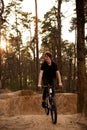 Cyclists in the forest on a track with slides for sport mountain Biking. Mountain bike jumping, extr