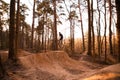 Cyclists in the forest on a track with slides for sport mountain Biking. Mountain bike jumping, extr