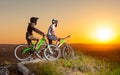 Cyclists with mountain bikes on the hill in the evening