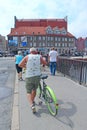 Cyclists ride bicycles on bridge in Warsaw. Tourists travel by bike