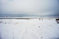 Cyclists ride on a snowy field in winter