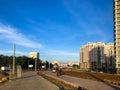 Cyclists travel along the bike path against the backdrop of a residential building. a white-red-white flag hangs on the house in