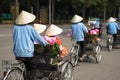 Cyclo pedicab driver wears conical hat on Hanoi street