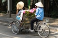 Cyclo pedicab driver wears conical hat on Hanoi street