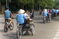 Cyclo pedicab driver wears conical hat on Hanoi street