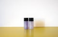 Cylinder bottles of bathroom amenity on golden shelf with white wall background