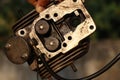 The cylinder head of an old diesel engine disassembled held in hand for repairing with a view of fuel inlets and its cooling fins Royalty Free Stock Photo