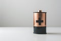 Cylindrical battery with copper top and black bottom, upright on white background. Royalty Free Stock Photo
