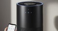 Cylindrical black air purifier with a top vent and glowing blue ring. Front panel features Royalty Free Stock Photo