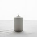Cylindrical candle with a single unlit wick is placed on a smooth, Royalty Free Stock Photo