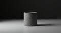 A cylindrical, gray, felt-textured pot is centered on a flat, minimalist surface. The lightin Royalty Free Stock Photo