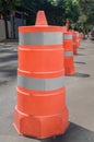 Cylindrical plastic structures in orange used to control traffic